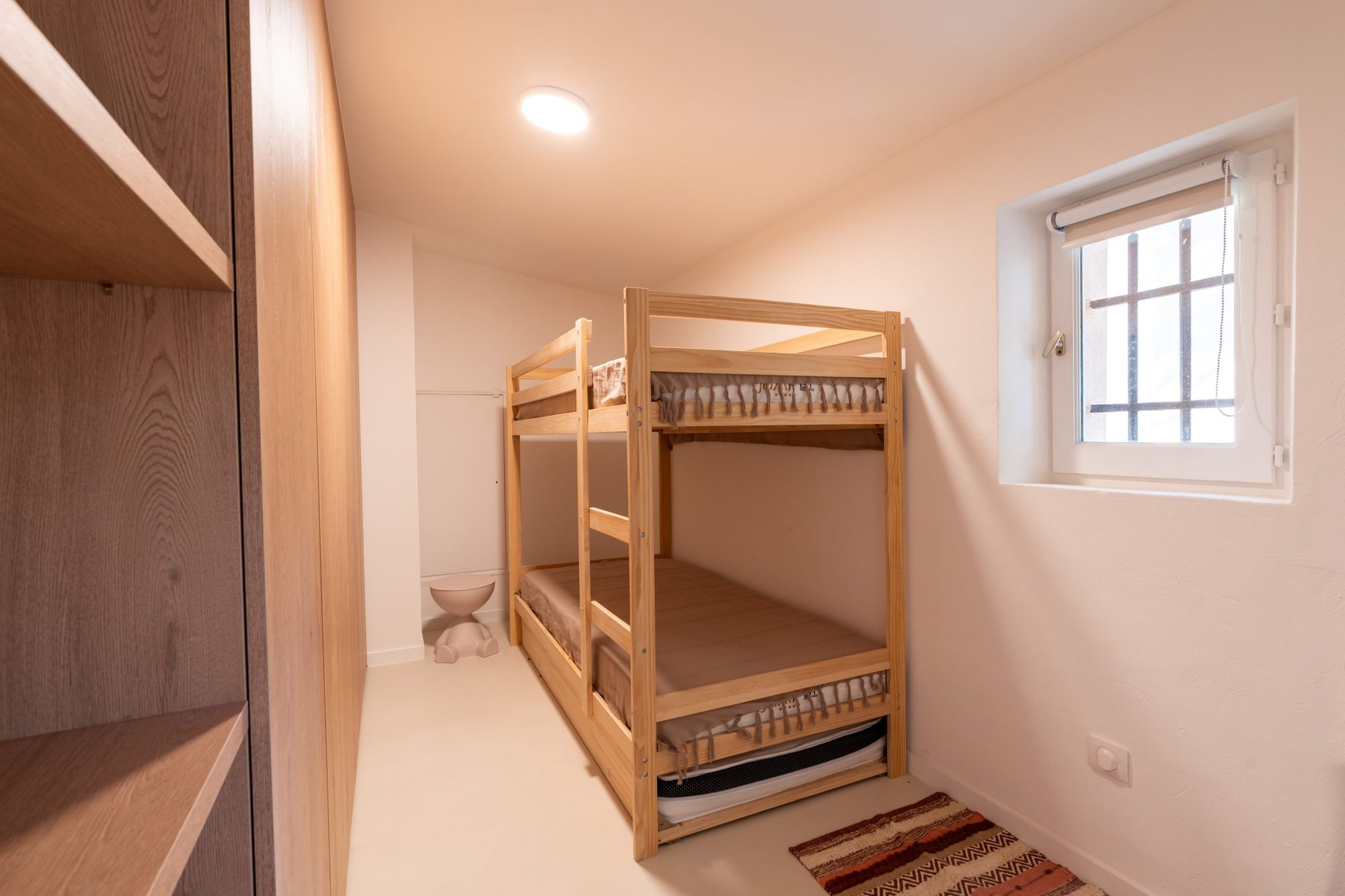 Chambre d'enfants équipée de lits superposés en bois clair.