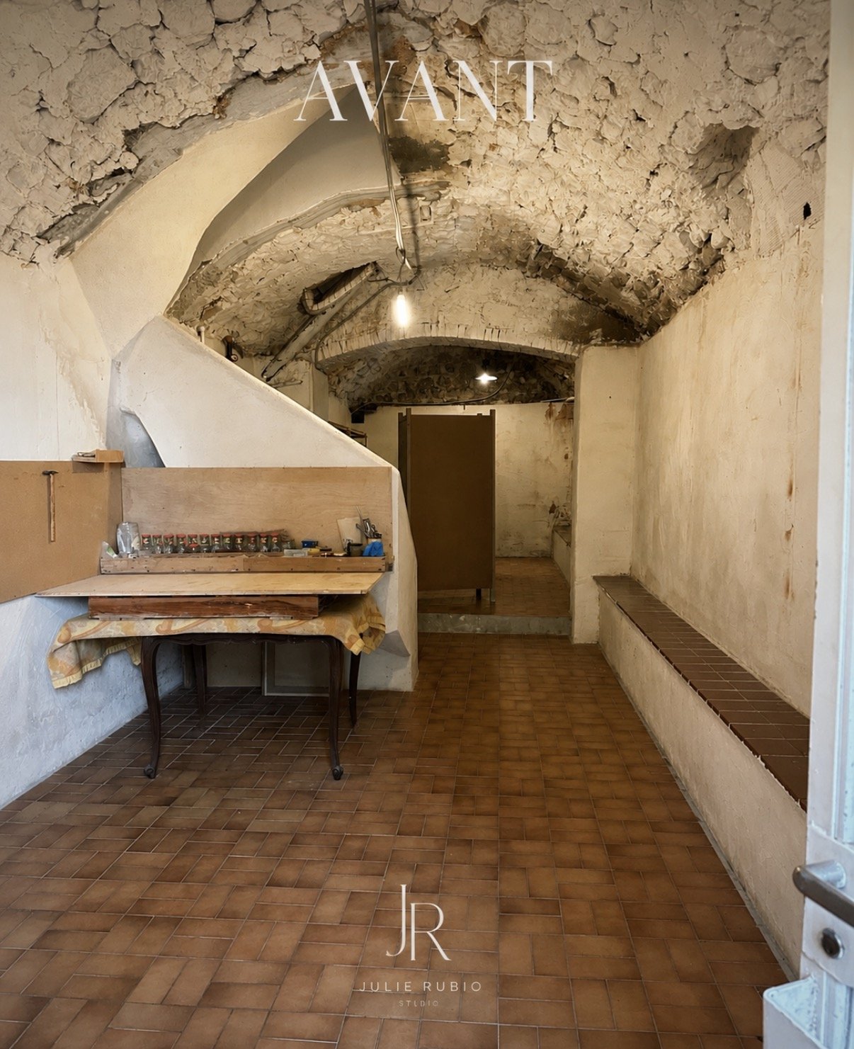 La cave voûtée avant travaux, murs de pierre brute et sol en tomettes.