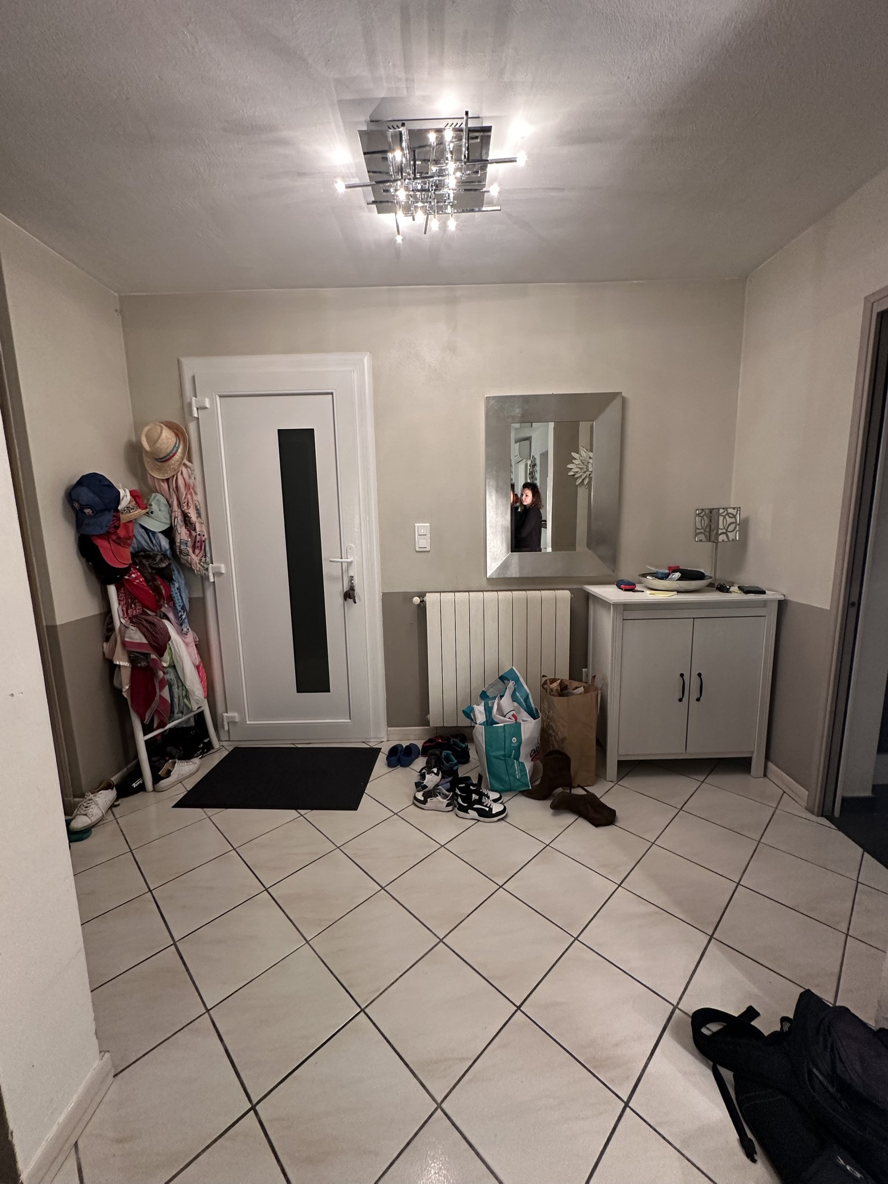 L'entrée avant travaux : manteaux et chaussures entassés près de la porte.